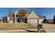 Inviting two-story home with a two car garage and manicured front lawn and brick accents under a clear sky at 11144 Echo Trl, Indianapolis, IN 46236