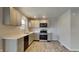 Modern kitchen featuring stainless steel appliances, gray cabinetry, white countertops, and plank flooring at 11144 Echo Trl, Indianapolis, IN 46236