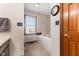 Neutral bathroom with a soaking tub, window, and wood door at 1146 Mount Vernon Dr, Greenwood, IN 46142