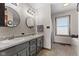 Modern bathroom featuring a double sink vanity, dual round mirrors, and walk-in shower at 1146 Mount Vernon Dr, Greenwood, IN 46142