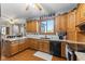Functional kitchen with wooden cabinetry, granite countertops, subway tile backsplash, and a black refrigerator at 1146 Mount Vernon Dr, Greenwood, IN 46142