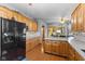 Bright kitchen with oak cabinets, granite countertops, and stainless steel appliances, leading to the living area at 1146 Mount Vernon Dr, Greenwood, IN 46142