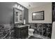 Stylish half bath with black marble-patterned walls, decorative mirror, and elegant fixtures at 11796 Sycamore St, Zionsville, IN 46077