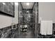 Modern bathroom featuring a sleek glass shower with black marble-patterned tile and contemporary fixtures at 11796 Sycamore St, Zionsville, IN 46077