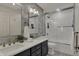 Modern bathroom featuring a double vanity, updated lighting, and glass-enclosed tub with shower at 11796 Sycamore St, Zionsville, IN 46077