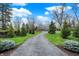 Long driveway winding through a lush green landscape, leading to a beautiful home in a serene setting at 11796 Sycamore St, Zionsville, IN 46077