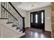 Elegant foyer with dark wood floors, a black wrought iron staircase, and a stylish front door at 11796 Sycamore St, Zionsville, IN 46077