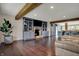 Spacious living room with hardwood floors, stone fireplace, and built-in shelves with an open concept design at 11796 Sycamore St, Zionsville, IN 46077