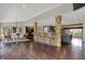 Open concept living space showcasing a bar, kitchen, and dining area with stone accents and hardwood flooring at 11796 Sycamore St, Zionsville, IN 46077