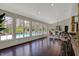 Sunlit living area with a bar, dining space, and wall of windows overlooking the pool and outdoor area at 11796 Sycamore St, Zionsville, IN 46077