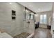 Elegant main bathroom boasting a glass shower, pebble floor, and a double sink vanity at 11796 Sycamore St, Zionsville, IN 46077