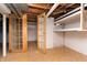 Unfinished basement with storage shelves and doorway to adjacent room at 1622 N Linwood Ave, Indianapolis, IN 46218
