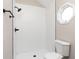 An elegant shower with white subway tiles and a modern black shower head, illuminated by an octagonal window at 1622 N Linwood Ave, Indianapolis, IN 46218