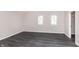 A spacious bedroom featuring gray walls and gray wood-look vinyl floors, with two bright windows at 1622 N Linwood Ave, Indianapolis, IN 46218