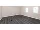 A modern bedroom with gray walls and gray wood-look vinyl floors, illuminated by two bright windows at 1622 N Linwood Ave, Indianapolis, IN 46218