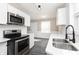 Renovated kitchen featuring stainless steel appliances, white cabinets and quartz countertops at 1622 N Linwood Ave, Indianapolis, IN 46218