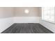 Bright living room with stylish gray flooring, paneled walls, and a unique octagonal window at 1622 N Linwood Ave, Indianapolis, IN 46218