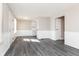 Open-concept living room featuring gray floors, paneled walls and view to the kitchen at 1622 N Linwood Ave, Indianapolis, IN 46218