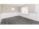 A bright living room with wainscoting, light gray walls, and gray wood-look vinyl floors, enhanced by two windows at 1622 N Linwood Ave, Indianapolis, IN 46218
