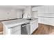 Open kitchen with white cabinets, stainless steel dishwasher, and gray countertops at 16429 Mount Logan Rd, Noblesville, IN 46060