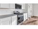Contemporary kitchen with white cabinets, a stainless steel microwave, and a range at 16429 Mount Logan Rd, Noblesville, IN 46060
