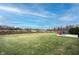 Grassy backyard with a patio area, lawn, and distant trees, offering ample outdoor space at 19252 Chestnut Grove Ln, Noblesville, IN 46062