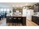 Bright, open kitchen featuring a center island, stainless steel appliances, and dark cabinetry at 19252 Chestnut Grove Ln, Noblesville, IN 46062