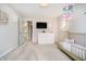 Bright bedroom featuring a crib, statement lighting, and white dresser at 19966 Chatham Green Dr, Westfield, IN 46074