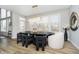 Bright dining area featuring a modern light fixture, hardwood floors, and windows overlooking the backyard at 19966 Chatham Green Dr, Westfield, IN 46074