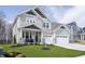 Charming two-story home featuring gray siding, stone accents, a well-manicured lawn, and a three-car garage at 19966 Chatham Green Dr, Westfield, IN 46074