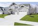 Charming two-story home featuring gray siding, stone accents, a well-manicured lawn, and a three-car garage at 19966 Chatham Green Dr, Westfield, IN 46074