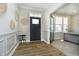 Elegant foyer with wood flooring, white wainscoting, and a stylish glass door leading to an office at 19966 Chatham Green Dr, Westfield, IN 46074