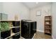 Laundry room featuring modern washer and dryer, with shelving and decorative elements for added functionality at 19966 Chatham Green Dr, Westfield, IN 46074