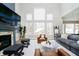 Bright living room with a fireplace, tall windows, and comfortable seating arrangement at 19966 Chatham Green Dr, Westfield, IN 46074
