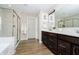 A luxurious bathroom featuring a double vanity, soaking tub, and tiled shower with glass door at 19966 Chatham Green Dr, Westfield, IN 46074