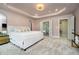 A light-filled main bedroom features an ensuite bath and a tray ceiling with a modern chandelier at 19966 Chatham Green Dr, Westfield, IN 46074