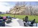 Relaxing outdoor patio featuring modern seating, umbrella, and expansive green backyard at 19966 Chatham Green Dr, Westfield, IN 46074