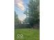 Spacious backyard with lush green grass, a wooden fence, and mature trees at 245 E Plum St, Anderson, IN 46012