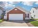 A brick and vinyl siding home with a two-car garage and a concrete driveway under a blue sky at 2709 Dawnlake Dr, Indianapolis, IN 46217