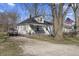 Charming one-story home with a welcoming front porch and American flag, set against a backdrop of mature trees at 3014 Alice Ave, Indianapolis, IN 46237