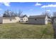 Wide view of the backyard and detached garage of a home with a grassy lawn and blue skies at 3022 Alice Ave, Indianapolis, IN 46237