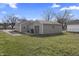 Exterior rear view of a home with a detached garage and grassy backyard under a partly cloudy sky at 3022 Alice Ave, Indianapolis, IN 46237