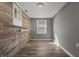 Small bedroom featuring a brick accent wall, natural light from a window and wood look flooring at 3022 Alice Ave, Indianapolis, IN 46237