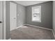A bright bedroom with a window allowing natural light, neutral walls, and soft carpet flooring at 3022 Alice Ave, Indianapolis, IN 46237