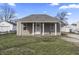 Charming one-story home featuring a covered porch, neutral siding, and a well-maintained front lawn under a clear blue sky at 3022 Alice Ave, Indianapolis, IN 46237