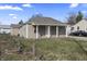 Cozy one-story house with a covered front porch, light-colored siding, and a partially fenced yard in a residential neighborhood at 3022 Alice Ave, Indianapolis, IN 46237