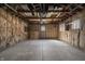 Unfinished garage with exposed insulation and rafters, concrete floor, and a window for natural light at 3022 Alice Ave, Indianapolis, IN 46237