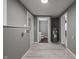Hallway leading to the bathroom showing essential hookups, with light wood-look flooring and gray walls at 3022 Alice Ave, Indianapolis, IN 46237