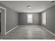 Bright and airy living room featuring gray walls and light-colored wood flooring, illuminated by two windows at 3022 Alice Ave, Indianapolis, IN 46237