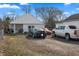 Cozy single-story home with a front yard, gravel driveway, and multiple cars parked out front at 3027 Alice Ave, Indianapolis, IN 46237